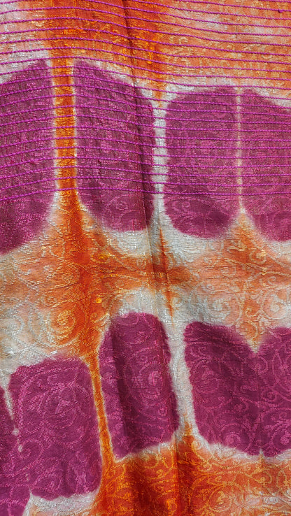 Close-up of fabric with purple shibori pattern on an orange background