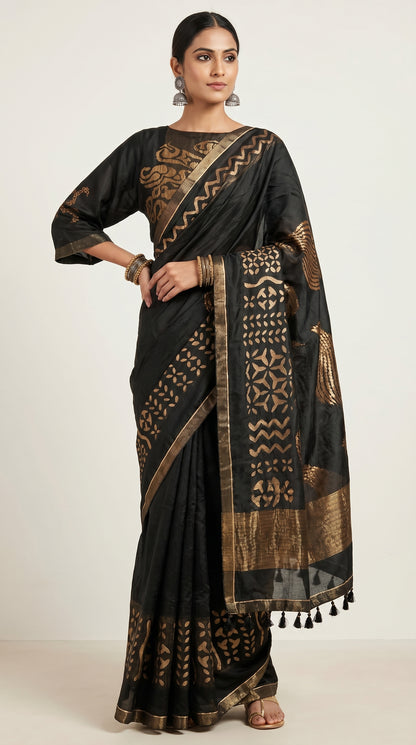 Woman wearing a black saree with gold patterns on a white background