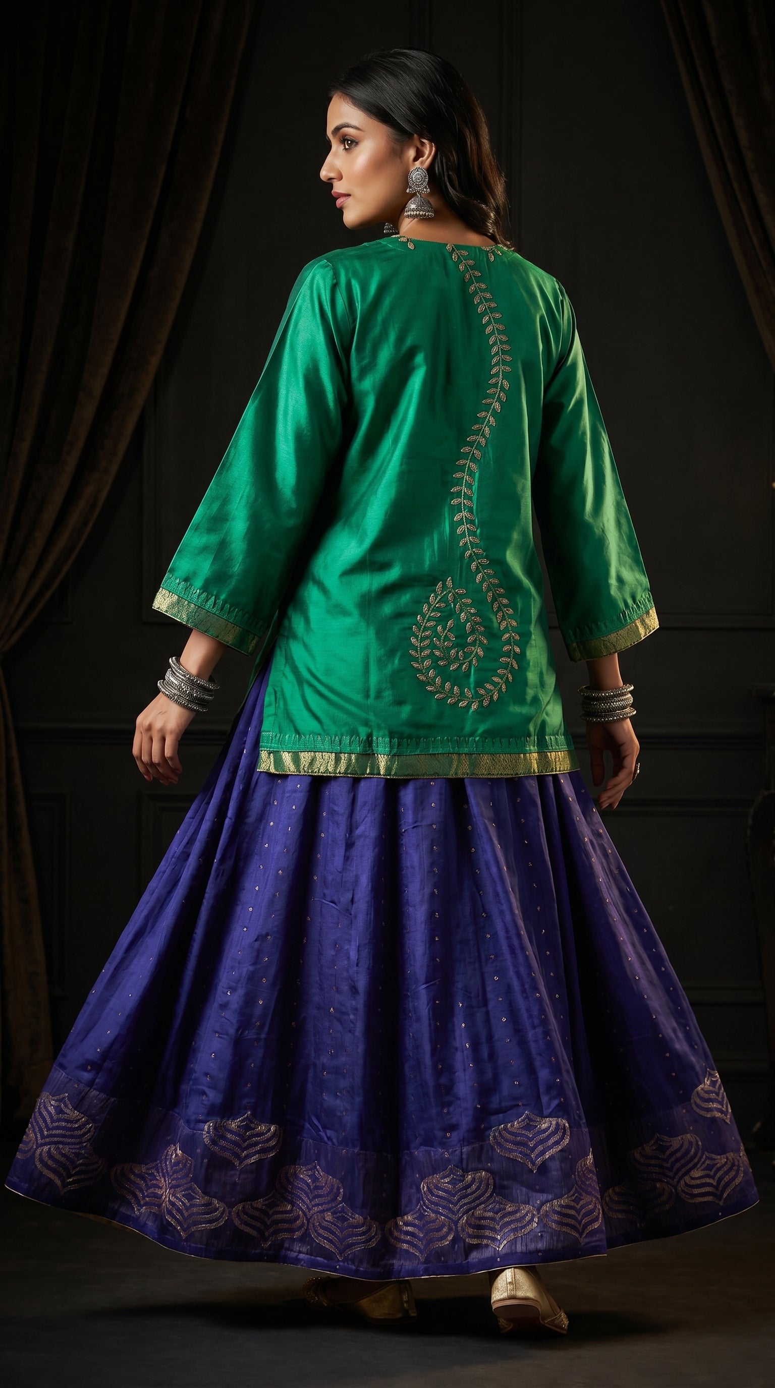 Woman wearing a green and purple traditional skirt set with intricate designs.