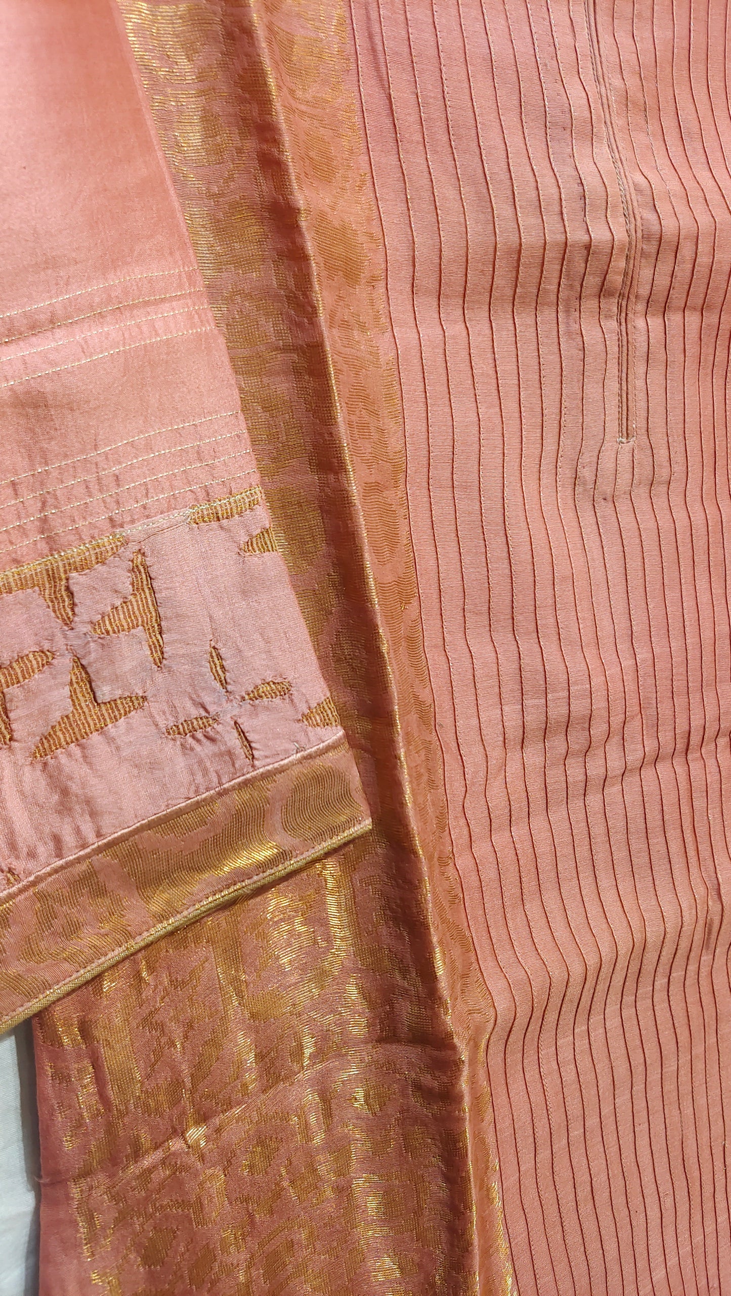 Close-up of a pink tunic with gold border and intricate patterns.