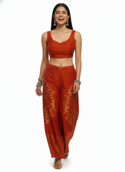 Woman wearing a rust plazoo pant with  designs on a white background